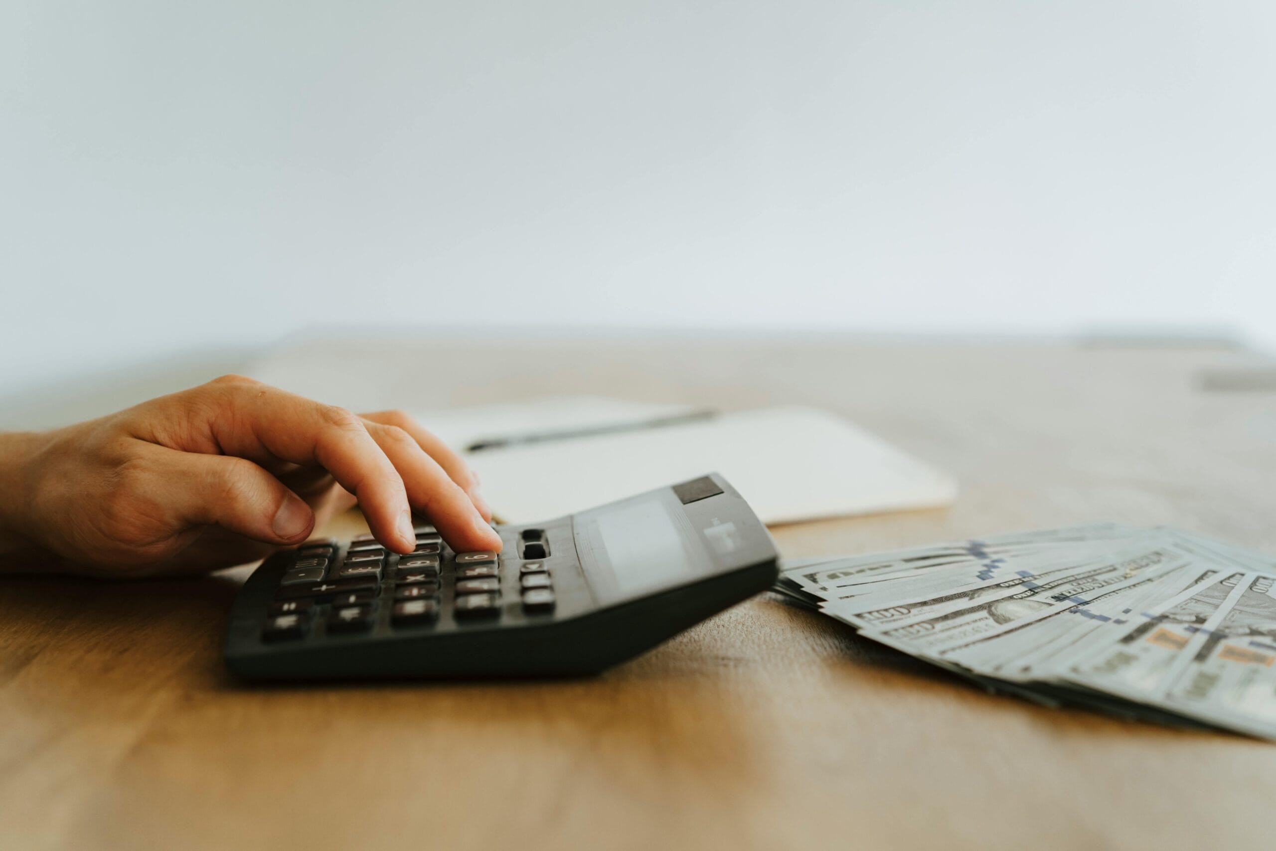 image showing hand using a calculator to determine Fixed vs. Variable Expenses