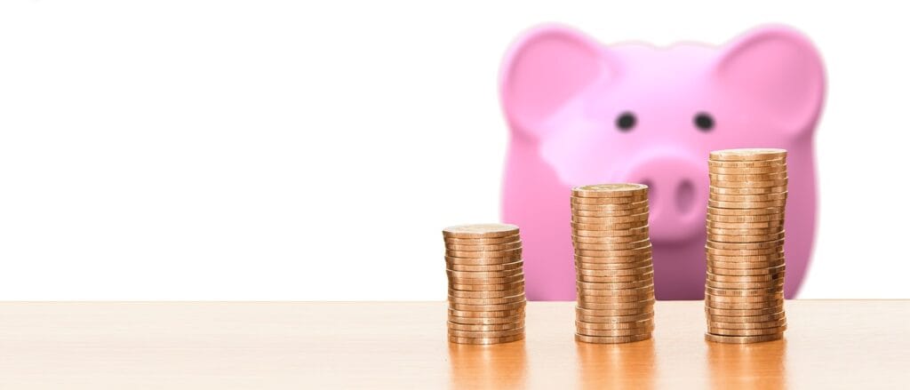 image of stacked coins and a piggy bank for budgeting mistakes beginners make. image of stacked coins and a piggy bank for budgeting mistakes beginners make.